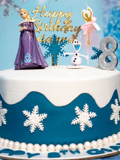 A beautiful Frozen-themed cake for an 8th birthday, complete with Elsa, Olaf, and sparkling snowflake decorations.