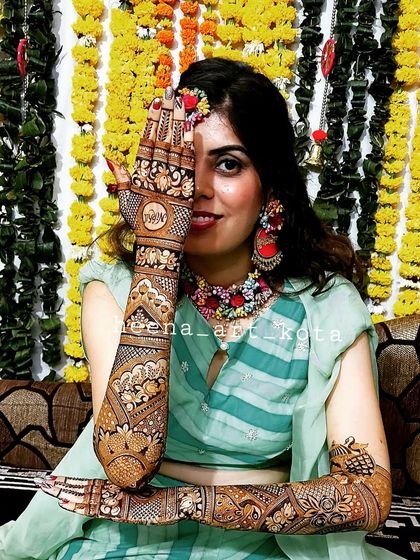 A stunning bride posing with her intricate back-hand mehndi design.
