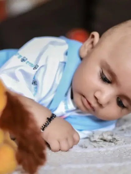 A quiet moment as a baby looks at a stuffed animal. We use familiar toys to make little ones feel comfortable during the shoot.