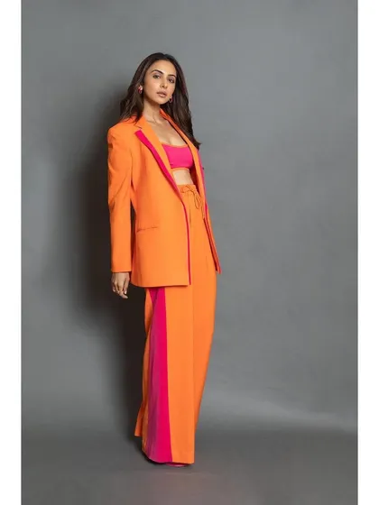 A full-body shot of the orange and pink pantsuit, a perfect rental for making a statement at any event.