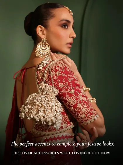 It’s all about the finishing touches. This handcrafted potli bag, with its cascading pearl tassels and delicate embroidery, is the perfect statement piece to elevate your festive saree or lehenga for a wedding reception or Diwali party.