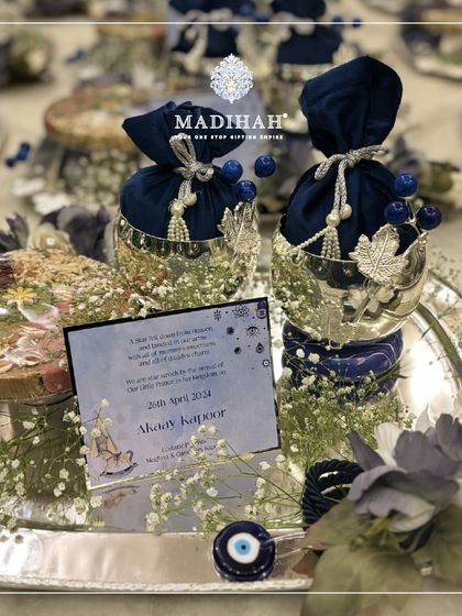 A close-up of the Evil Eye hamper, focusing on the personalized announcement for 'Akaay Kapoor'. The deep blue and silver elements create a striking and meaningful gift to celebrate a new arrival.