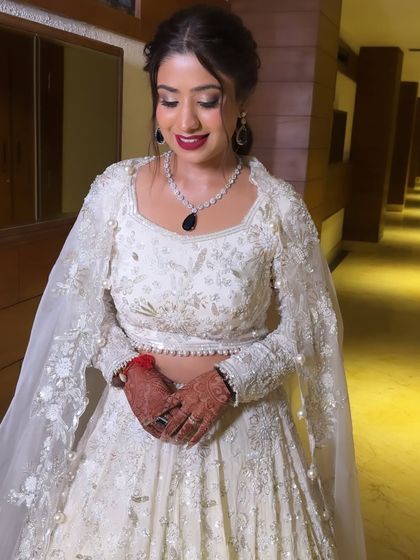 A moment of quiet confidence before the event. This shot highlights the bold red lip and shimmering eye makeup, a classic combination for a glamorous engagement party.