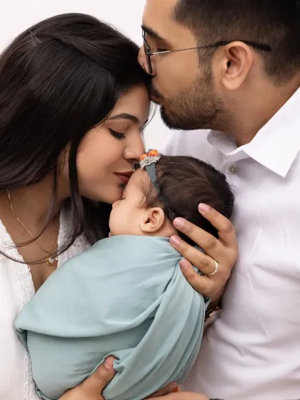 An intimate close-up of a family sharing kisses with their newborn. This photo is filled with love and tenderness, capturing the deep affection of new parents.