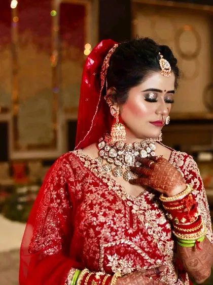 My bride Juhi looking absolutely radiant. This look features shimmery golden eyeshadow and a bold red lip, paired with a stunning diamond necklace set for a touch of modern elegance.