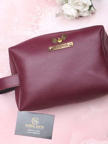 A beautiful maroon leather pouch, personalized with a name and a heart-with-wings charm.