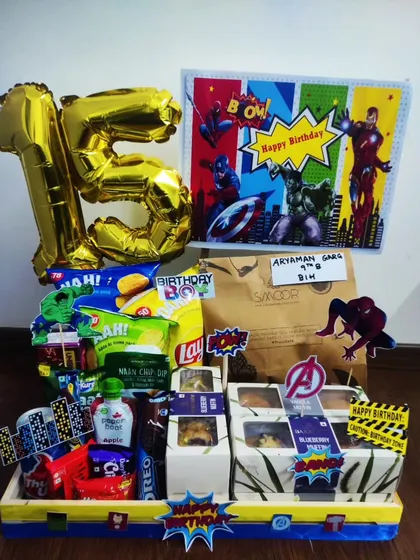 For a young superhero fan's 15th birthday, I assembled this action-packed Avengers hamper. It includes themed snacks, donuts, and bold 'POW' and 'BAM' cutouts to bring the Marvel universe to their celebration.