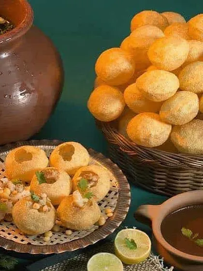 We pay close attention to the details. This spread shows the fresh components of our classic pani puri, including crisp puris, savory filling, and our signature spicy and sweet waters served in traditional earthenware.