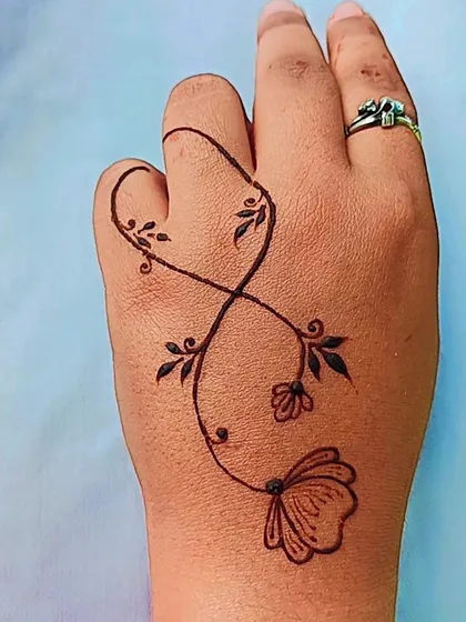 An infinity loop design created with a delicate floral vine. This is a great example of a small, meaningful, and trendy henna tattoo.