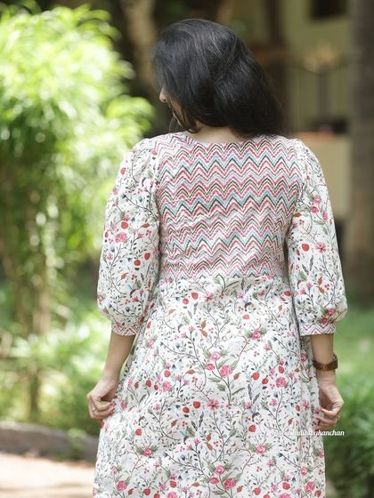 A view of the beautiful back detailing on our white floral kurta, featuring a contrasting chevron print panel. It's all in the details.