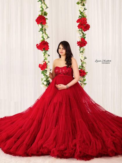 A fairytale moment on a floral swing. This beautiful red gown with its voluminous tulle skirt creates a truly magical and romantic scene.