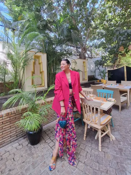 A vibrant daytime look with a pink blazer and floral pants. This is a great way to add a pop of color to your vacation wardrobe.