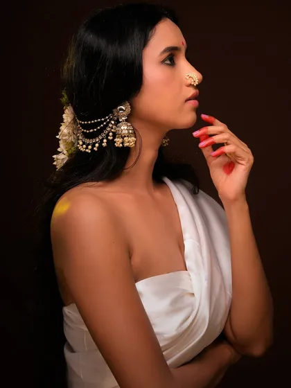 A side profile from the same series, this shot emphasizes the beautiful hair accessory and the elegant line of the model's neck. The lighting creates a soft glow on her skin.