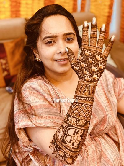 This back-of-hand design features a beautiful monogram with a floral touch, surrounded by intricate elephant patterns. It's a perfect blend of personalization and tradition.