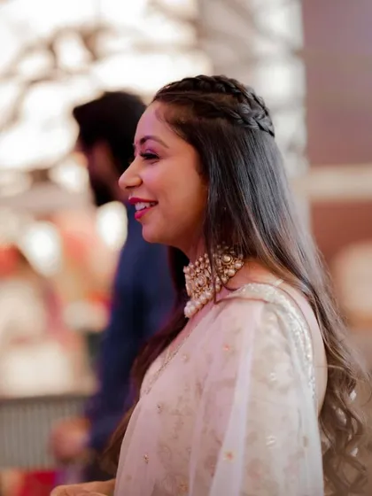 A close-up profile of the half-braided hairstyle, showing the neatness of the braid and the softness of the waves.