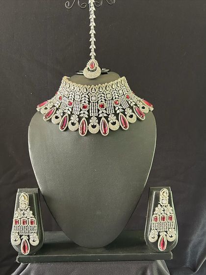 If you just need a statement necklace, this white stone choker with red stone accents is a great option. It comes with matching earrings and a maang tikka.