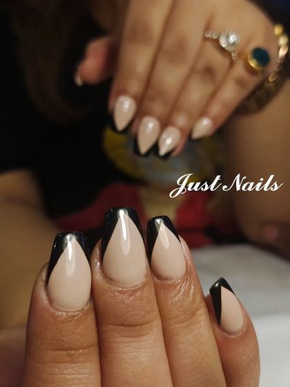 A close-up of the sharp and chic v-shaped black French manicure.