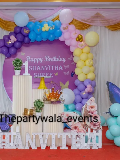 A wider view of the purple butterfly theme, showing the full setup on a red carpet. The light-up name sign makes it feel very personalized.