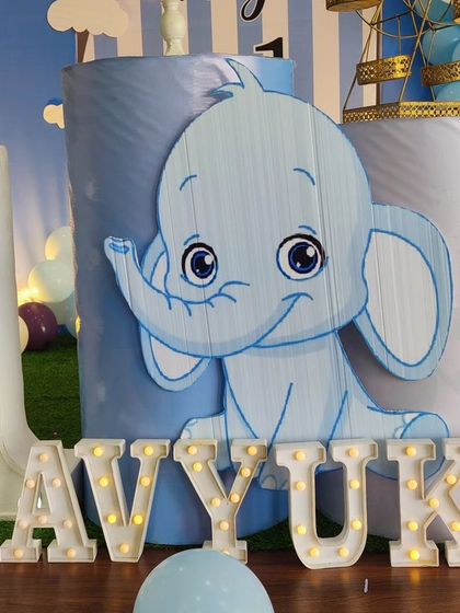 A close-up of the baby elephant-themed decor, showing the cute character cutout and the 'AVYUKT' marquee letters.
