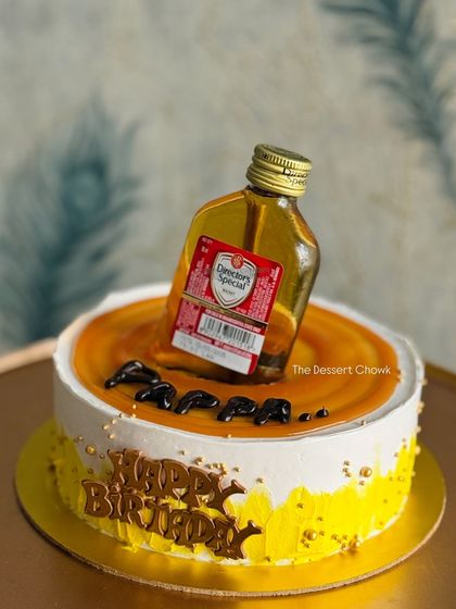 A fun "anti-gravity" cake design featuring a miniature bottle of Officer's Choice whisky. This butterscotch cake is a great choice for a milestone birthday.