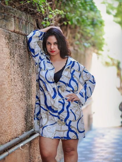 A strong and powerful pose in an outdoor alley. The composition uses the leading lines of the walls to draw the eye directly to her confident stance.