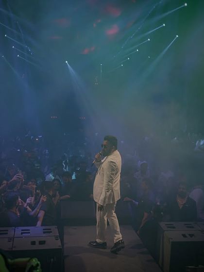 We create an immersive atmosphere in any venue. This wide shot captures Mika Singh on stage at Babylon, enveloped in atmospheric haze and dramatic lighting, drawing the entire club's attention.