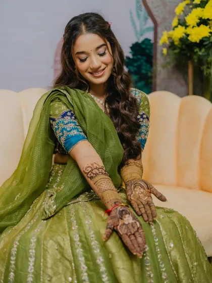 The bride showing off her beautiful mehendi design, her makeup perfectly complementing the traditional vibe.