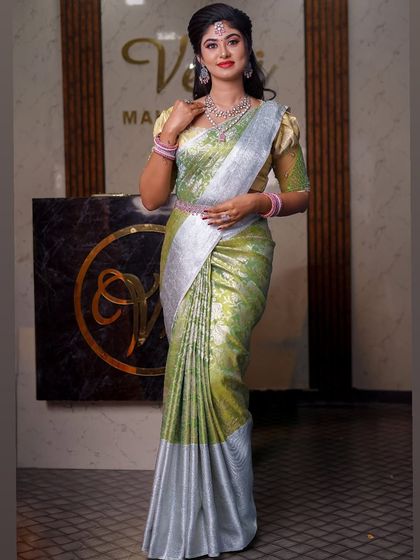 A light green and silver saree that creates a very fresh and modern look. The draping is soft and elegant, suitable for a daytime event or reception.