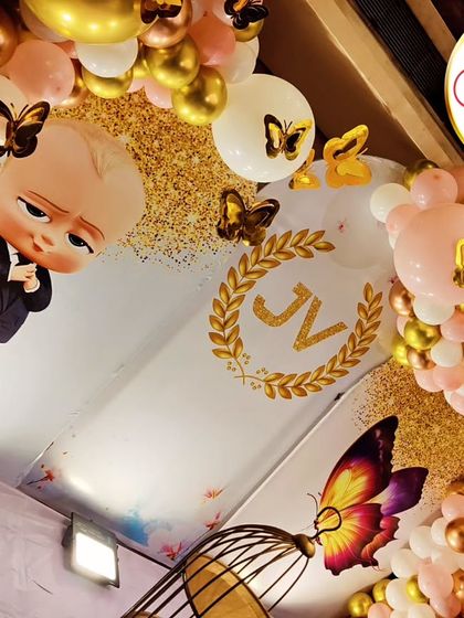 A tilted, artistic shot of a Boss Baby and Butterfly-themed setup, highlighting the gold and pink balloon details.