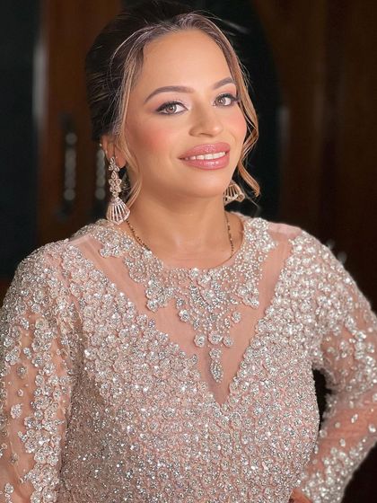 A close-up of a client ready for a party. The makeup is soft and glamorous, with a focus on glowing skin and defined eyes.