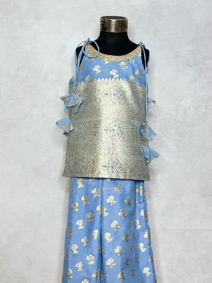 Another look at our versatile Mogra collection in a lovely powder blue. This shows a kurta-pajama set for a boy and a matching top and pants set for a girl, both featuring the same elegant brocade fabric.