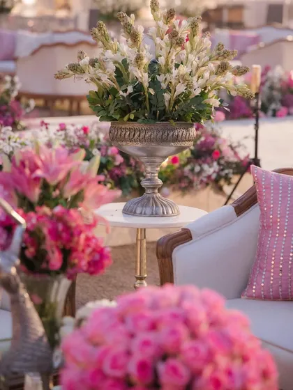 A glimpse into the decor of a pastel wonderland. I used lush arrangements of pink lilies and white tuberoses in vintage-style urns to create a seating area that felt both luxurious and romantically soft.
