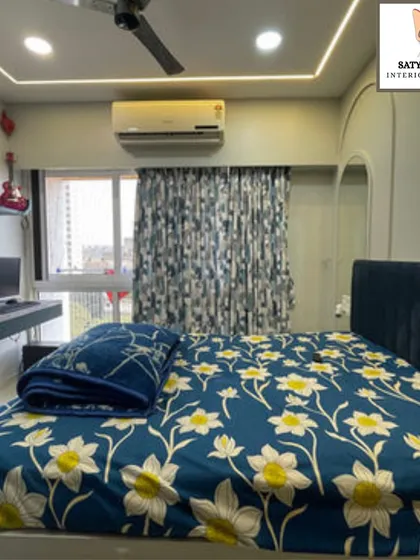 A full view of the bedroom, showcasing the floral bedding that adds a touch of cheerfulness to the modern design.