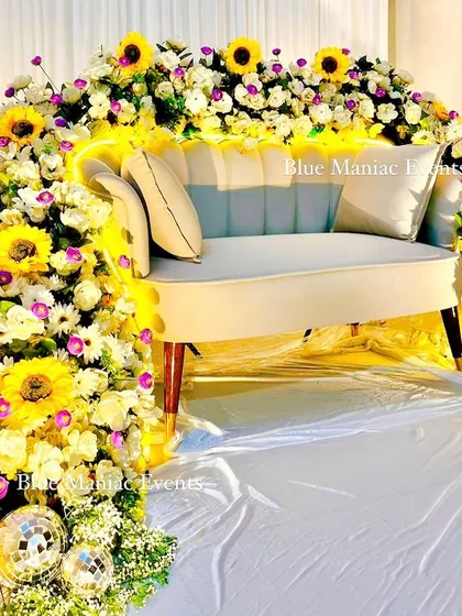 I love creating unique focal points for your events. This floral couch for a Roka ceremony is a great example, where the seating itself becomes a work of art, enveloped in an arch of sunflowers, daisies, and other beautiful artificial blooms.