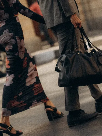 A detail shot focusing on their movement. The close up on their legs, his bag, and their linked hands tells a story of a journey taken together.