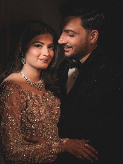 A classic, softly lit portrait that focuses on the couple's serene connection. The bride's gentle smile and the groom's fond expression are captured beautifully in this timeless image.