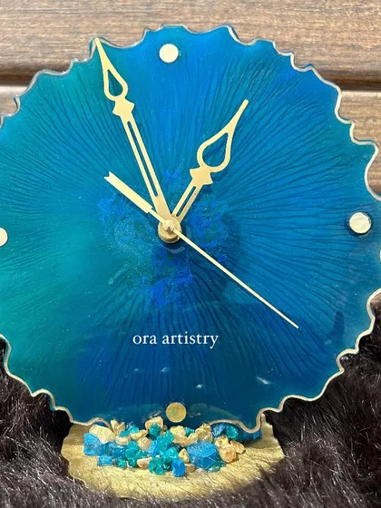 A mini ocean-themed clock with a scalloped edge and a base of blue crystals. Perfect for a desk or bedside table.