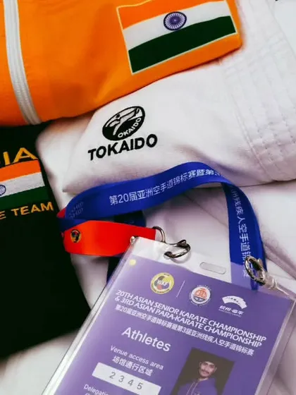 My gear laid out before a competition. The Indian flag on my jacket, my karate gi, and my athlete pass are all symbols of the hard work it took to get here.
