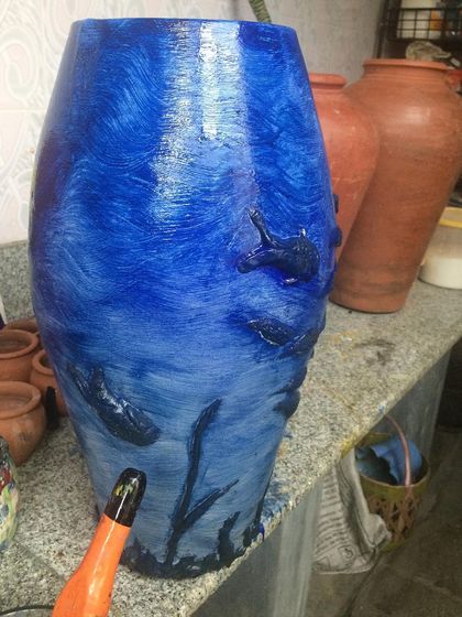 This large terracotta vase is being transformed with an underwater scene. We teach you how to properly prime and paint on porous surfaces like terracotta for a lasting finish.