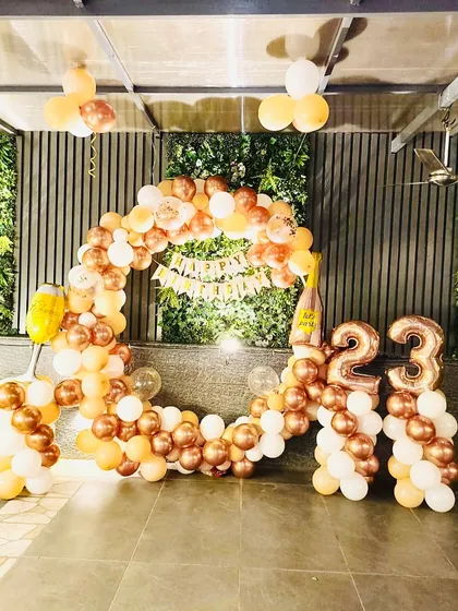 Celebrating 23 with a stunning rose gold and white balloon arch. The setup includes a 'Happy Birthday' banner and number balloons, making it a perfect, Instagrammable spot for a birthday party.