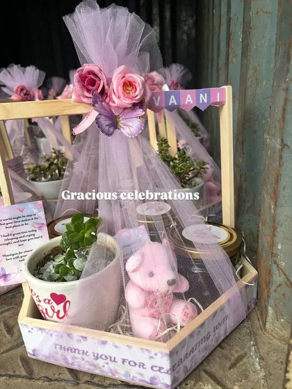 Pretty in lilac for a baby girl's celebration. This hamper features a butterfly theme with a customized planter, a pink teddy bear candle, and jars of treats.