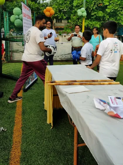 Showing a young participant how to hold the pads and throw a punch. My goal is to make martial arts accessible and fun for kids of all ages.