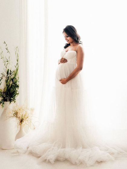 A full-length portrait that feels so light and airy. We used the natural light from the studio window to create this high-key effect, making her white gown and the moment feel serene and beautiful.