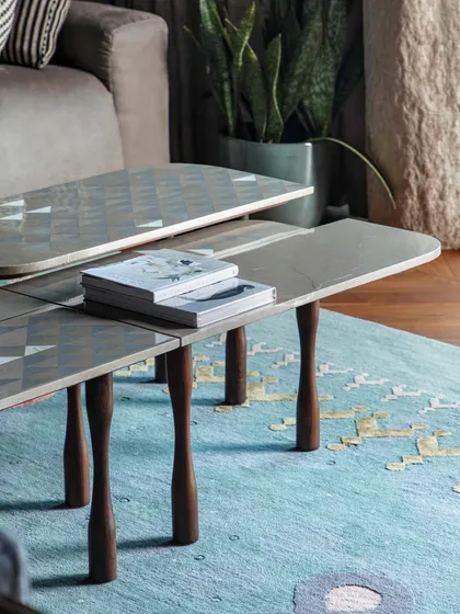 A detail of the family lounge at 'The 42, Kolkata'. This custom coffee table features an inlaid art top, set against the vibrant 'Kolam' rug from Jaipur Rugs, showcasing our focus on functional art.
