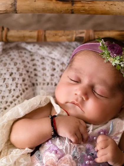 A sweet sleeping baby girl in a beautiful lace outfit. The soft textures and peaceful expression make this a truly precious portrait.