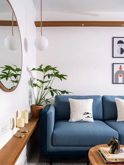 A corner of the 'Footloose' studio apartment, where a custom wooden ledge runs along the wall, serving as a console table and connecting the living area to the rest of the open-plan space.