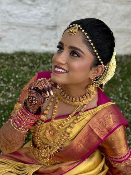 A beautiful South Indian bride, her traditional gold jewellery and silk saree perfectly complemented by her dark mehendi stain.