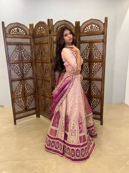 This pink lehenga with a contrasting purple banarasi dupatta is a beautiful blend of modern and traditional.