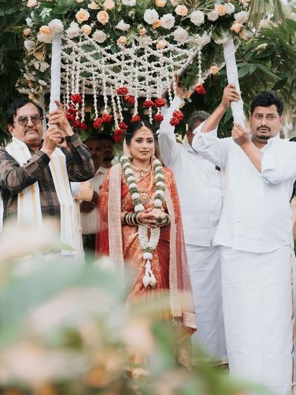 The bride's procession, as she is carried in under a beautiful floral canopy held by her family. This shot captures a beautiful South Indian wedding tradition.