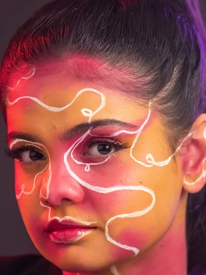 Creative lighting adds another layer of drama to this already striking artistic makeup look.